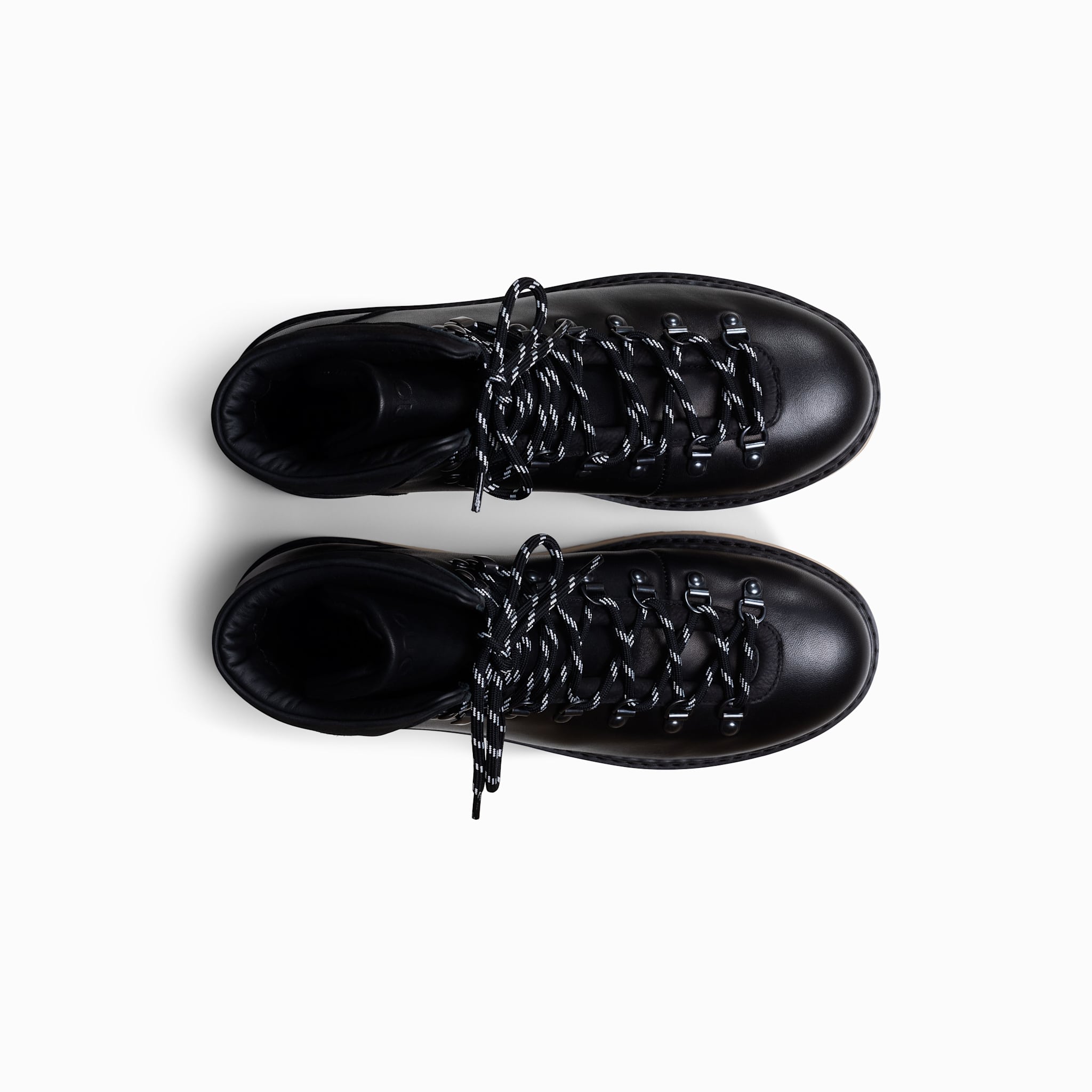 Pair of black leather boots with decorative lacing on a white background