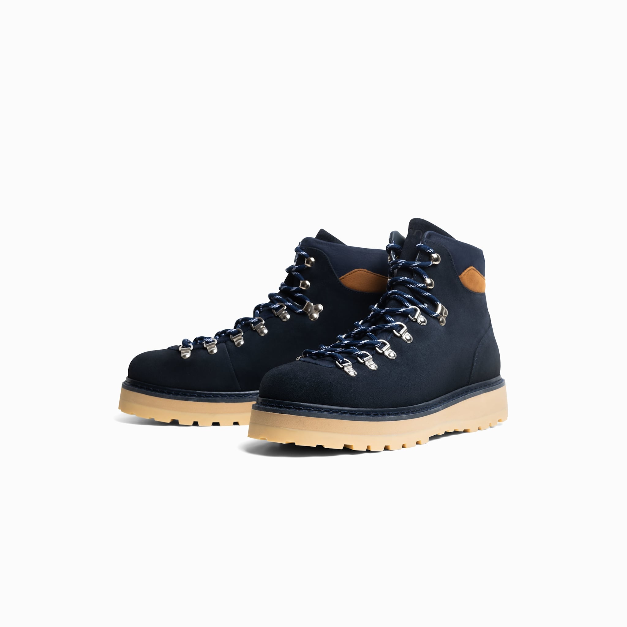 Pair of navy blue hiking boots with tan soles on a white background