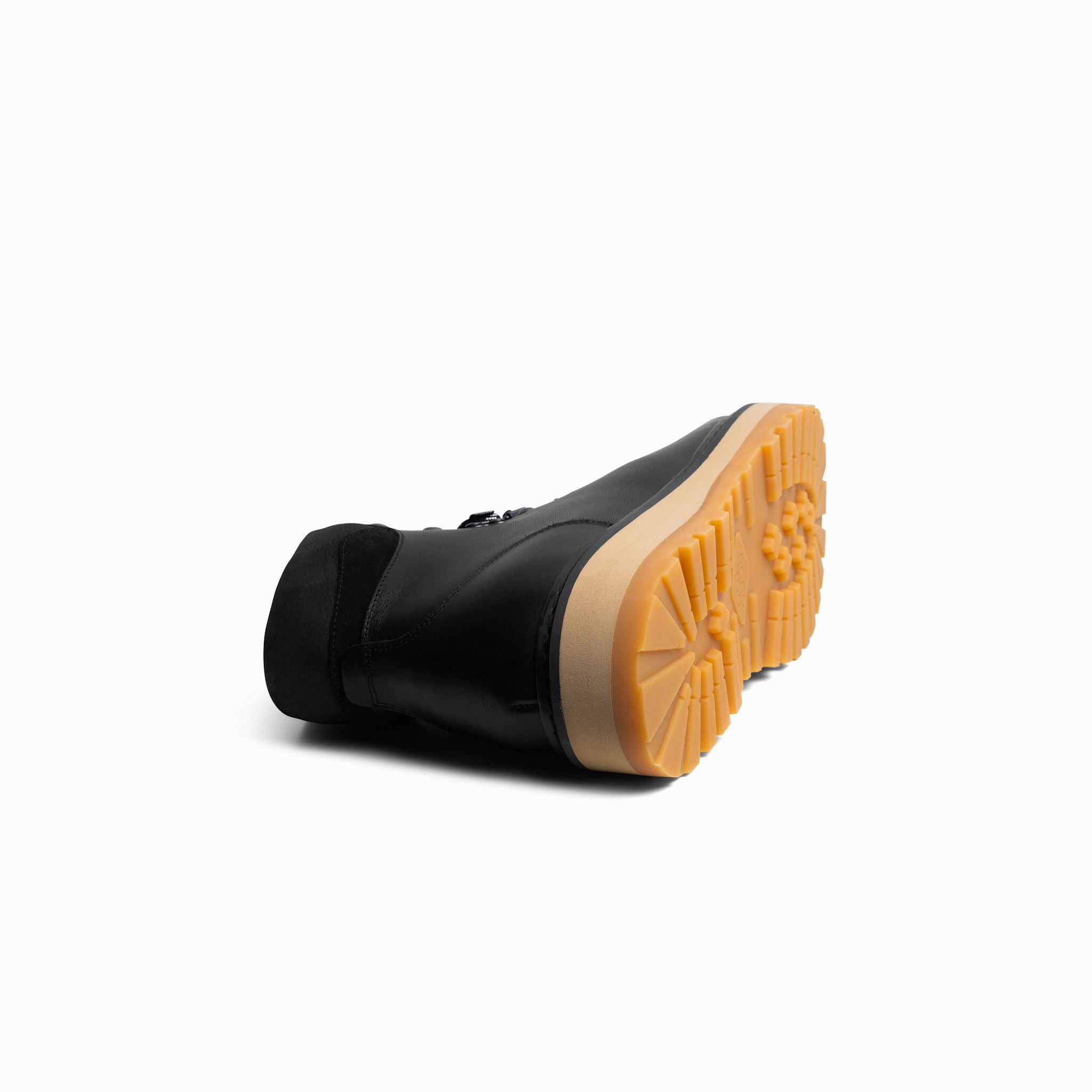 Black boot with tan sole on a white background